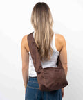 Brown Shield Crossbody shopper i vandafvisende materiale. Den brune farve changere i lyset.  