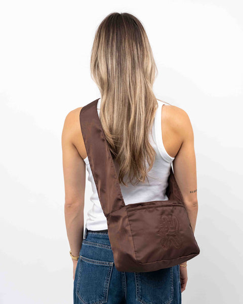 Brown Shield Crossbody shopper i vandafvisende materiale. Den brune farve changere i lyset.  