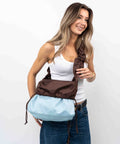 Brown_Shield_Midi med vendbar funktion. Båret som crossbody shopper, med ruffle strop. Brown og Ice Blue shopper. 