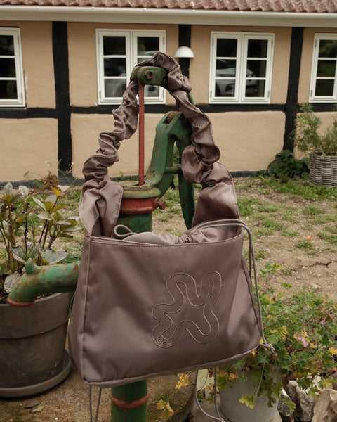 Grey Shield Midi Shopper. Rufflestrop og snørelukning for at holde tasken kompakt.
