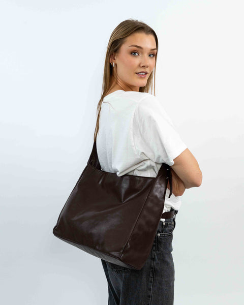 Mørkebrun VEGA skuldertaske fra IGEN båret crossbody.